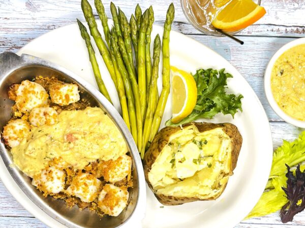 Tender, sea scallops from the port of New Bedford surrounding a savory stuffing of fresh clams and tiny shrimp; smothered under a creamy saffron sauce with bits of lobster; two sides included